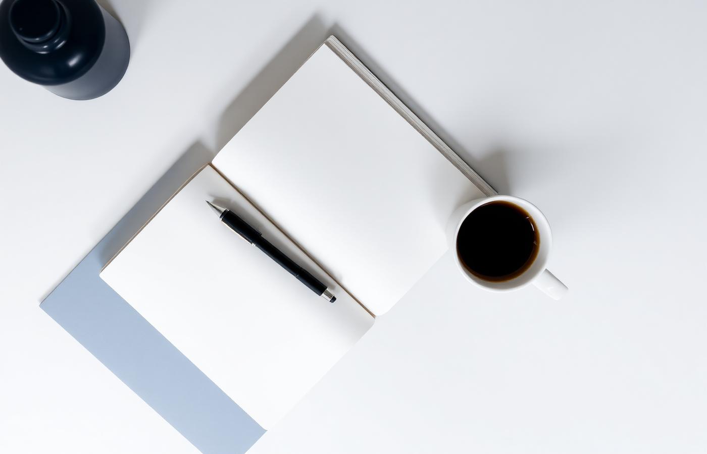 Notebook, pen and coffee on a study desk